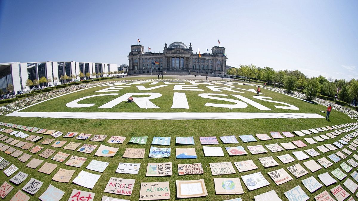Activists of the Fridays for Future movement place protest posters for climate protection in front the German parliament in Berlin