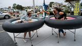 Restaurant guests use social distancing devices made of rubber tubing as Fish Tails Bar and Grill opens for in person dining during the pandemic. Ocean City, Maryland, USA 