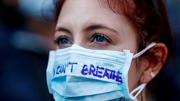 Mulher participanuma manifestação em Roma, Itália, usando uma máscara contra a Covid-19 Mulher participanuma manifestação em Roma, Itália, usando uma máscara contra a Covid-19