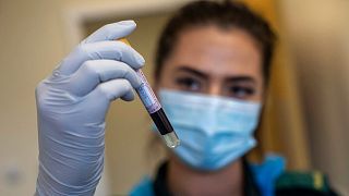 A paramedic holds a blood sample during a coronavirus antibody testing program at the Hollymore Ambulance Hub, in Birmingham, England, Friday, June 5, 2020.