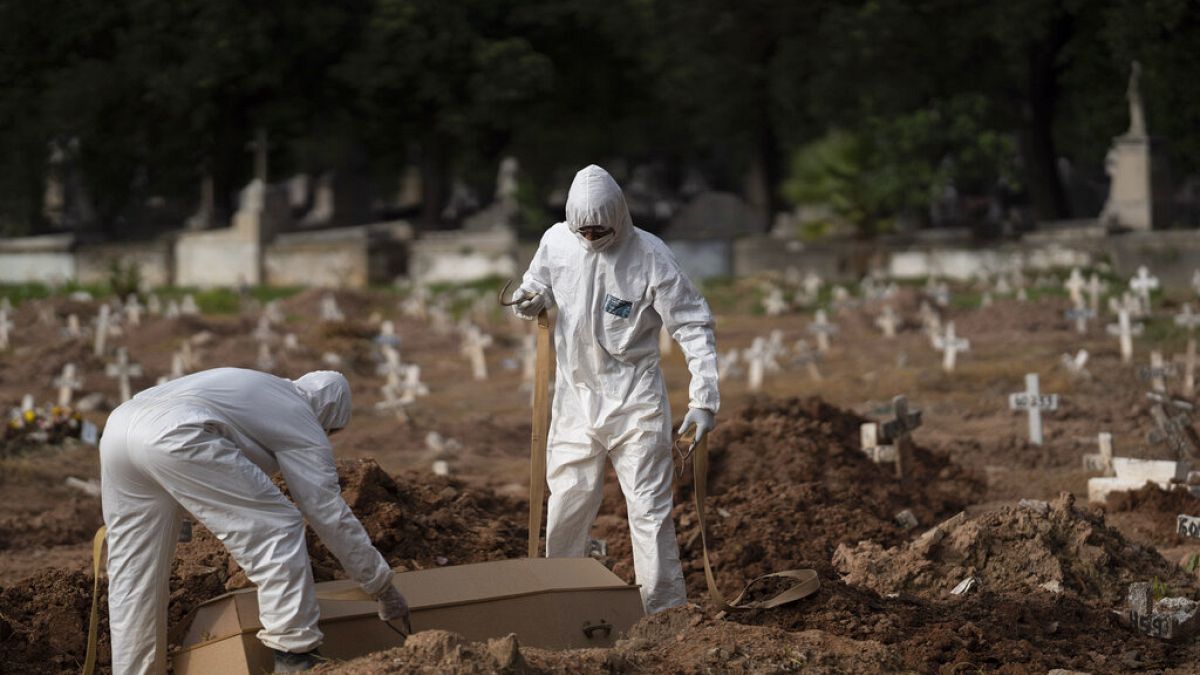 Brezilya'da koronavirüsten ölenlerin mezarcılık işlerini yapan iki görevli.