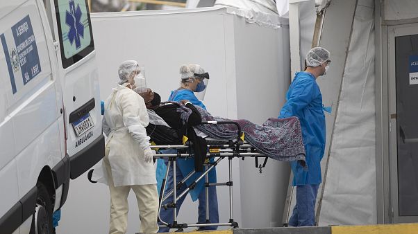 Brezilya'nın Rio de Janeiro kentinde Covid-19 semptomları gösteren bir hasta, sahra hastanesine getirilirken Brezilya'nın Rio de Janeiro kentinde Covid-19 semptomları gösteren bir hasta, sahra hastanesine getirilirken
