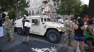 Demonstrators talk to National Guard soldiers as they protest Saturday, June 6, 2020, near the White House in Washington, over the death of George Floyd.