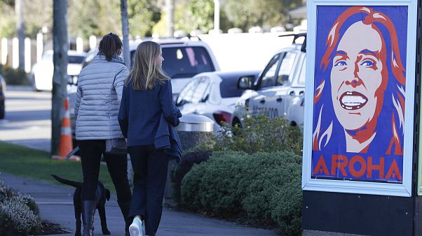 Gente pasa ante un cartel de la primera ministra, Jacinda Ardern Gente pasa ante un cartel de la primera ministra, Jacinda Ardern