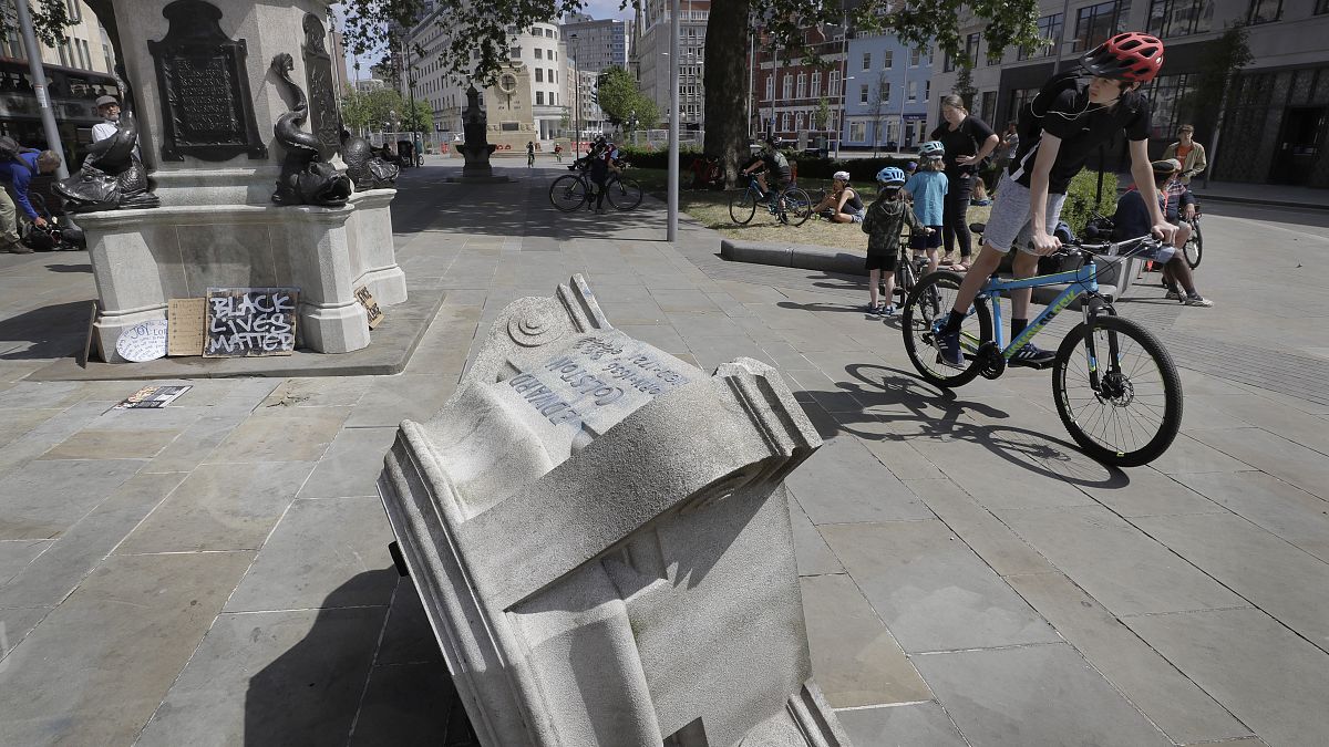 People look at the pedestal of the toppled statue of Edward Colston in Bristol, England, Monday, June 8, 2020.