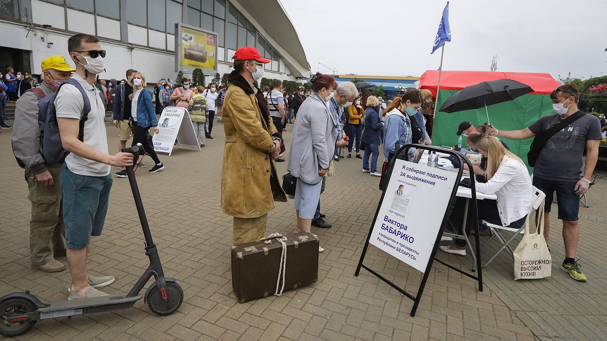 People, wearing face masks to protect against coronavirus, give their signatures in support of potential presidential candidates in the presidential elections in Minsk