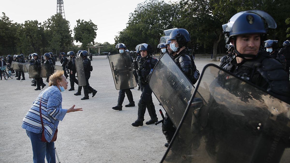 An elderly woman haggles French riot police during a demonstration in Paris, France, Saturday, June 6, 2020, to protest against the recent killing of George Floyd.