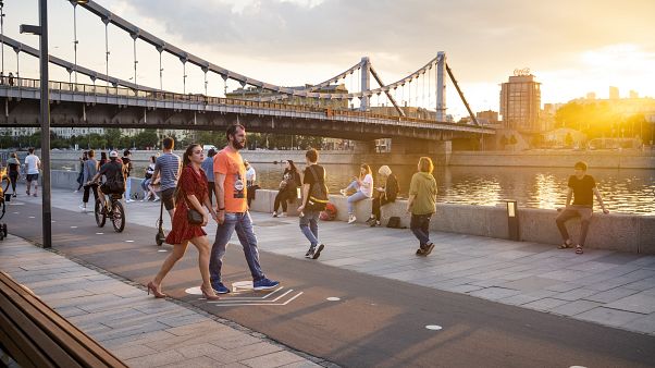 Люди прогуливаются по набережной в Москве. Люди прогуливаются по набережной в Москве.