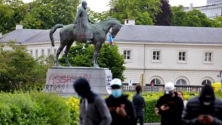 A statue of Belgium's King Leopold II is defaced with the words 'assassin' prior to a Black Lives Matter protest rally in Brussels
