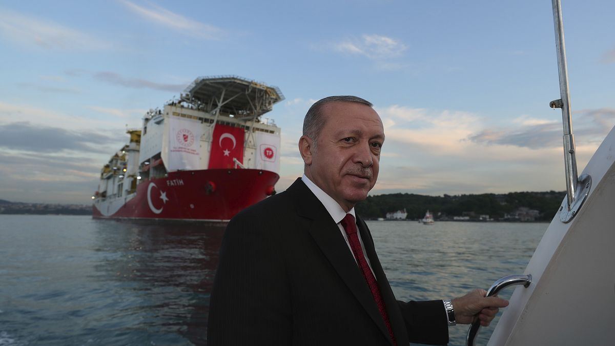 Turkey's President Recep Tayyip Erdogan, pose for photographs, backdropped by 'Fatih' 