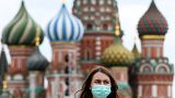 A woman wearing a protective face mask walks in front of the Saint Basil's Cathedral during the annual book fair on the Red Square in downtown Moscow on June 6, 2020