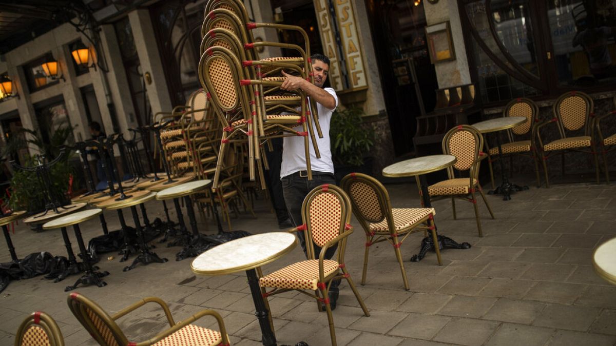 A waiter sets up a restaurant terrace during the partial lifting of coronavirus COVID-19 lockdown regulations in Brussels, June 8, 2020. (AP Photo/Francisco Seco)