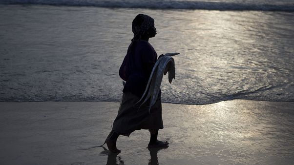 Une femme tient un poisson sur la plage de saint-Louis, Sénégal, le 18 mai 2013 Une femme tient un poisson sur la plage de saint-Louis, Sénégal, le 18 mai 2013