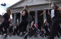 Tour Guide protesters dressed in black in front of the Pantheon, clapping hands and banging lids
