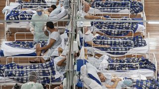 COVID-19 patients lie on beds in a field hospital built inside a gym in Santo Andre
