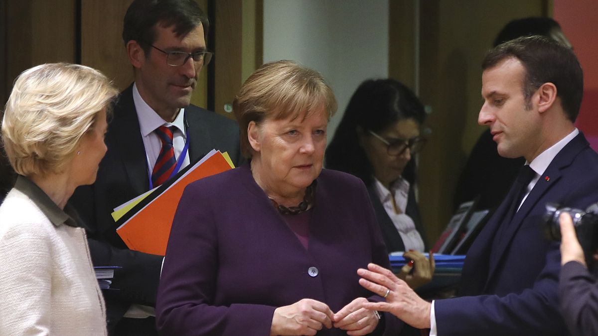 French President Emmanuel Macron, right, speaks with German Chancellor Angela Merkel, center, and European Commission President Ursula von der Leyen