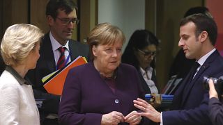 French President Emmanuel Macron, right, speaks with German Chancellor Angela Merkel, center, and European Commission President Ursula von der Leyen