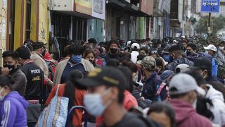 Cientos de personas, vendendores ambulantes, compradores y transeúntes, abarrotan una calle en Lima