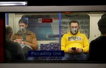 Passengers wearing face masks travel on a Piccadilly Line underground train in London, March 20, 2020 (file).
