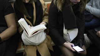 Woman looking at mobile phone on a New York subway