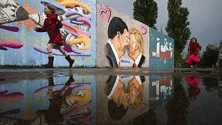 Graffiti depicts U.S. President Trump, right, and China's President Xi Jinping kissing each other with face masks on a wall in Berlin