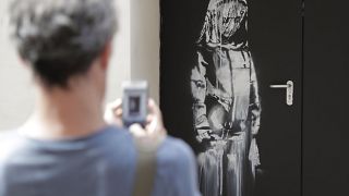 A work by controversial British artist known as Banksy, entitled 'Riot Green', on show at the Andipa Gallery in London Wednesday, Feb. 27, 2008.