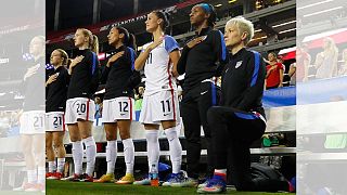 مگان راپینو بازیکن تیم ملی فوتبال زنان آمریکا که هنگام پخش سرود ملی زانو زده است