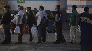 Guatemalans deported from the U.S., wearing a mask as a precaution against the spread of the new coronavirus
