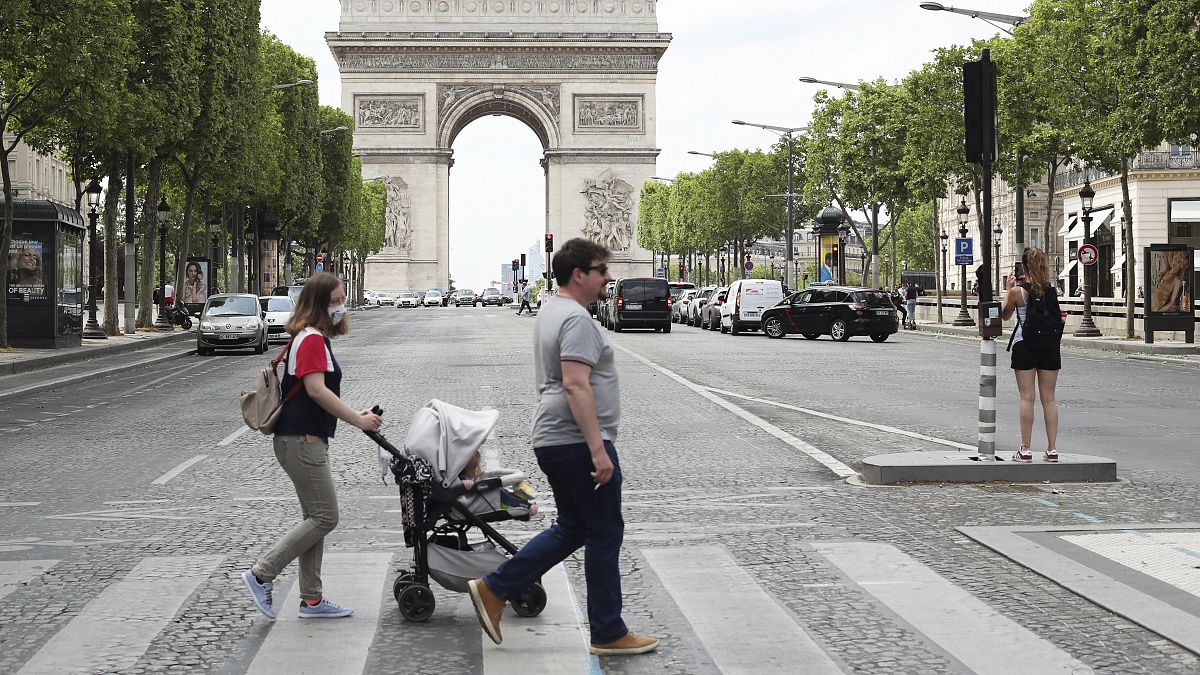 People stroll on the Champs Elysees avenue in Paris, Wednesday, June 3, 2020.