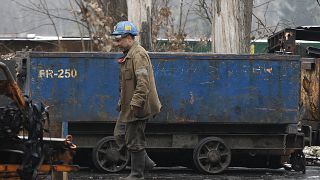 In this Nov. 21, 2018 photo a miner passes by a lorry at at the Wujek coal mine in Katowice, in Poland's southern mining region of Silesia.