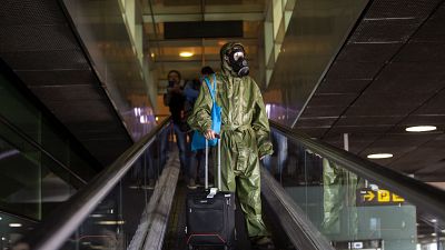 A passenger wearing a protective suit arrives from London at the Barcelona airport, Spain, on Friday, May 15, 2020. 