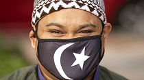 Malezya'da koronavirüs sebebiyle maske takmış bir Müslüman.