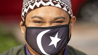 Malezya'da koronavirüs sebebiyle maske takmış bir Müslüman.