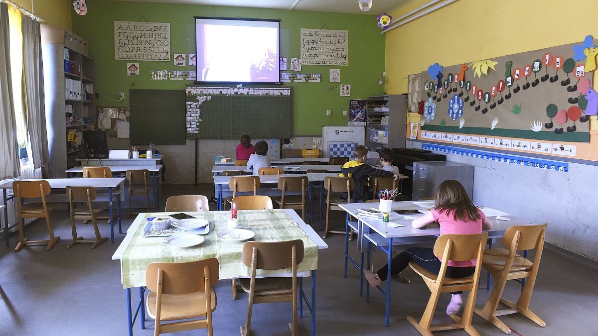 FILE:  Primary school pupils watch their teacher speak on the display in a school in Budapest, 31 March, 2020. 