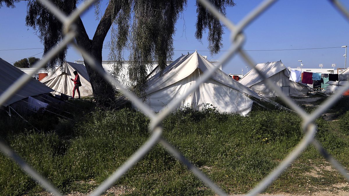 مهاجرٌ يسير قرب الخيام داخل مخيم للاجئين في كوكينوتريميثيا قرب العاصمة القبرصية، نيقوسيا