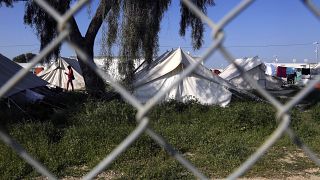 مهاجرٌ يسير قرب الخيام داخل مخيم للاجئين في كوكينوتريميثيا قرب العاصمة القبرصية، نيقوسيا