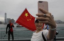 Pro-China supporters take a selfie with a Chinese national flag to support police and anti-violence during a rally at a park in Hong Kong.