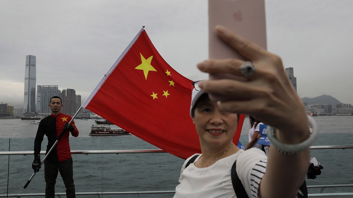 شخص يحمل العلم الصيني في هونغ كونغ