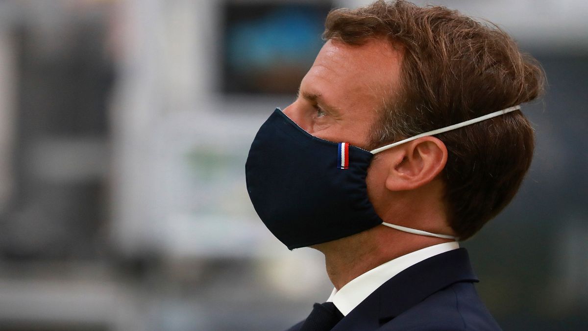 French President Emmanuel Macron wears a  a protective face mask, as he visits a Valeo manufacturer plant, in Etaples, Tuesday May 26, 2020.