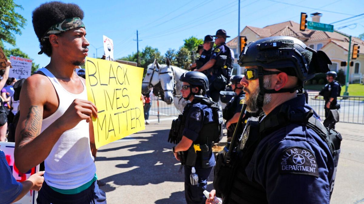 A protester and police face each other during a demonstration near a private event attended by President Donald Trump, Thursday, June 11, 2020.