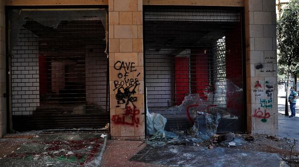 Un uomo guarda i negozi danneggiati durante una protesta antigovernativa a Beirut, Libano Un uomo guarda i negozi danneggiati durante una protesta antigovernativa a Beirut, Libano