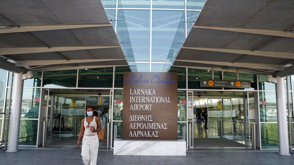A woman wearing mask walks at Cyprus' main airport at Larnaca