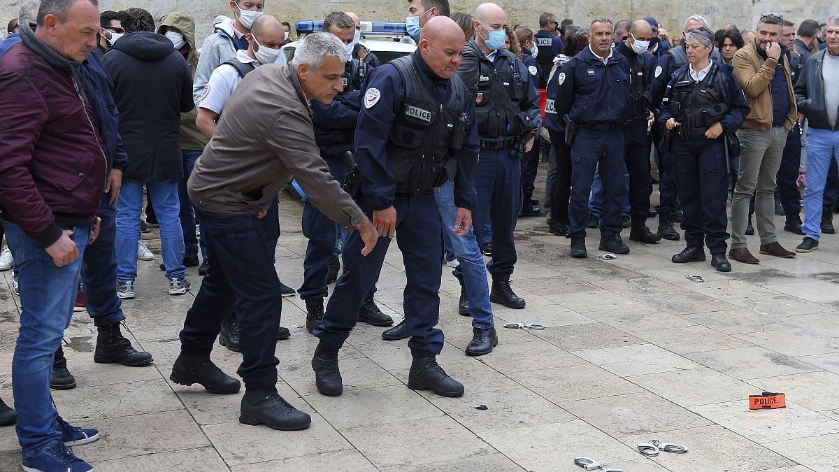 French police throw handcuffs and arm band on the ground following demonstrations against police brutality and racism. 
