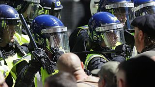 British police officers in riot gear scuffle with members of far-right groups protesting against a Black Lives Matter demonstration, in central London, Saturday, June 13, 2020