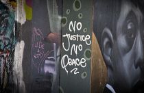 Mid shot mural reading "No Justice No Peace"