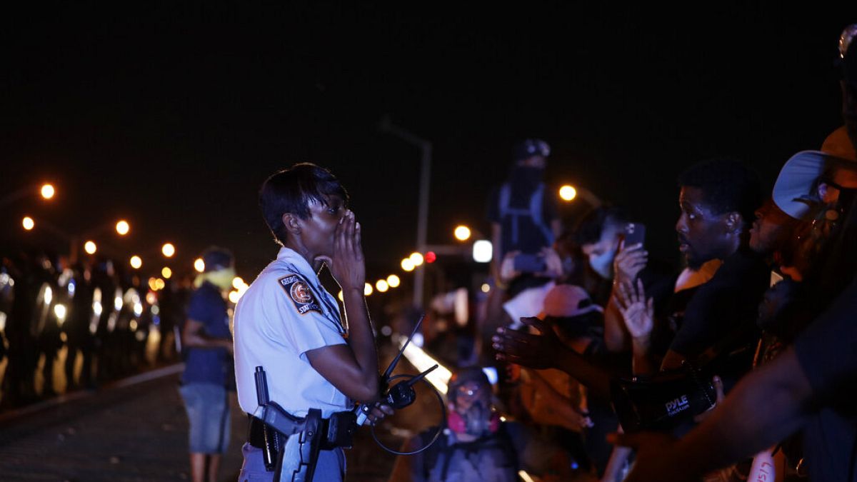 Un officier avertit des manifestants samedi 13 juin 2020 à Atlanta où Rayshard Brooks a été abattu par la police