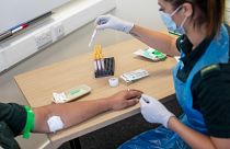 A paramedic carries out a blood draw during an antibody testing programme in Birmingham, England, on June 5, 2020