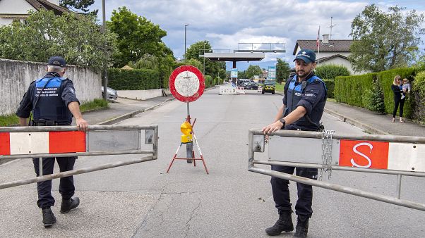 Dos guardias fronterizos abren la barrera que cerraba el acceso a la aduana, en Thonex, cerca de Ginebra, Suiza, el domingo 14 de junio de 2020. Dos guardias fronterizos abren la barrera que cerraba el acceso a la aduana, en Thonex, cerca de Ginebra, Suiza, el domingo 14 de junio de 2020.