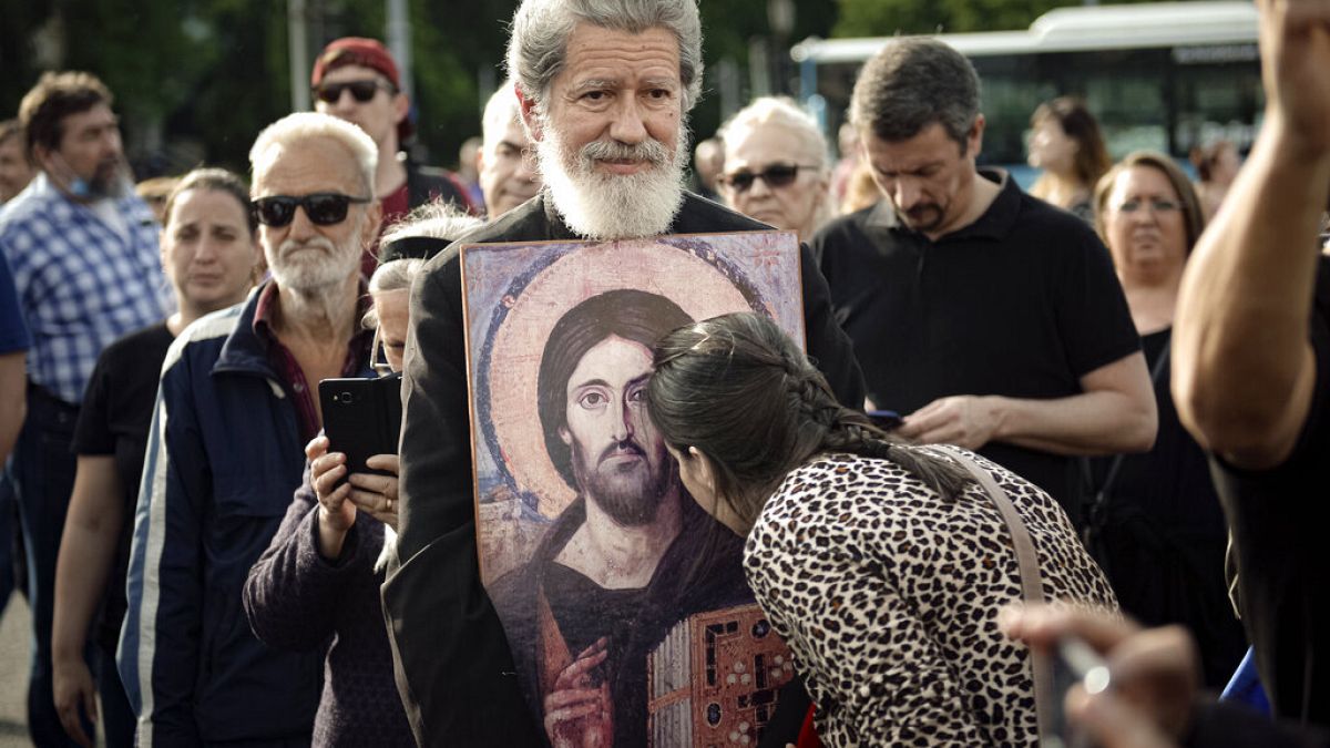Nő csókol meg egy ikonosztázt egy tüntetésen, amit a koronavírus miatti bevezetett korlátozó intézkedések ellen tartottak Romániában