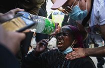 Демонстранту промывают глаза после того, как полиция распылила слезоточивый газ. Стокгольм, Швеция.